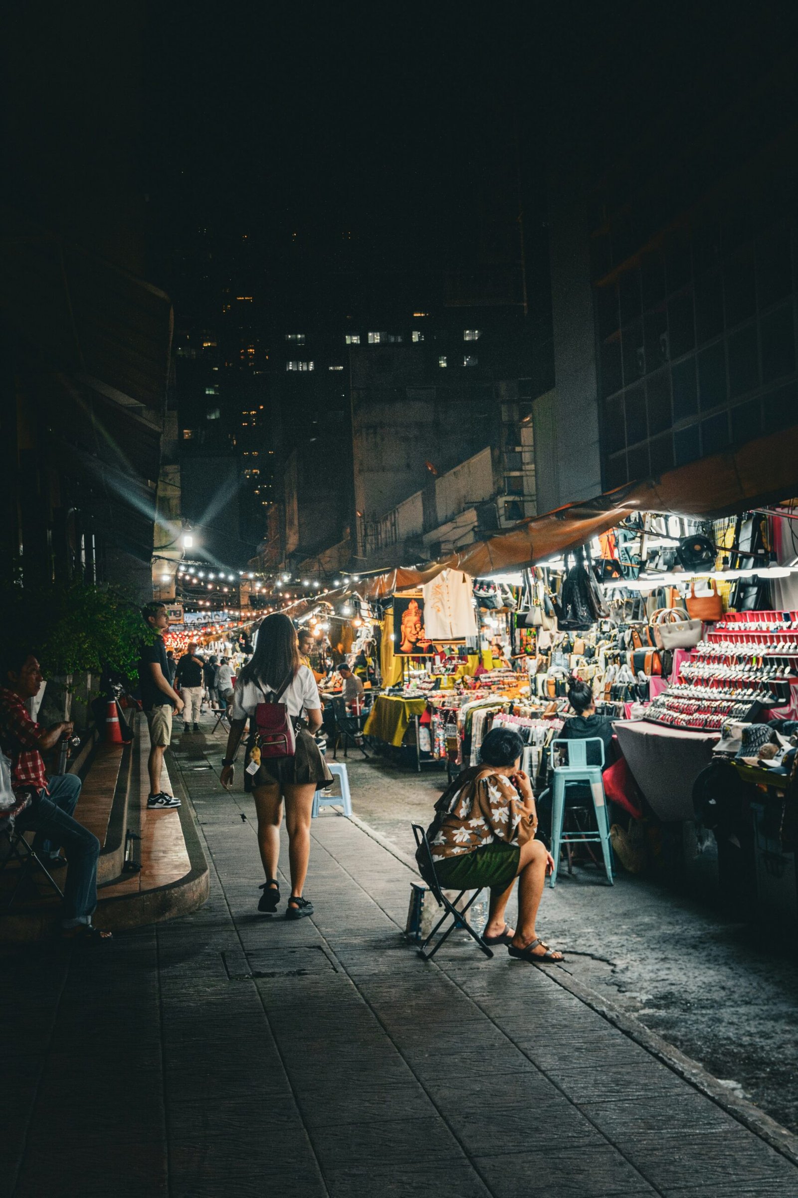 a woman sitting in a chair in a market